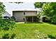 Large backyard with a trampoline, swings, covered patio, shed, and a green lawn at 1252 Jasmine Dr, Greenfield, IN 46140