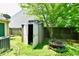 Backyard shed with an open door on a green lawn and fire pit near a wooden fence at 1252 Jasmine Dr, Greenfield, IN 46140