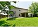 Large backyard with a trampoline, swings, covered patio, and a green lawn at 1252 Jasmine Dr, Greenfield, IN 46140