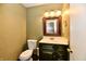Cozy bathroom with a vanity, mirror, lighting, and toilet with olive and tan wall color scheme at 1252 Jasmine Dr, Greenfield, IN 46140