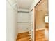 Walk-in closet with shelving and storage solutions, adjoining bedroom with wooden floors at 1252 Jasmine Dr, Greenfield, IN 46140