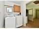 Functional laundry room with white washer and dryer and storage cabinet at 1252 Jasmine Dr, Greenfield, IN 46140