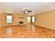 Open-plan living room featuring wood flooring, ceiling fan, and bright, natural light from the windows at 1252 Jasmine Dr, Greenfield, IN 46140