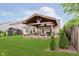 A large, covered patio with ample seating, a landscaped yard, and partial fencing defines this backyard at 12535 Old Pond Rd, Noblesville, IN 46060