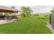 Beautiful backyard with a large green lawn, covered patio, and lush landscaping at 12535 Old Pond Rd, Noblesville, IN 46060
