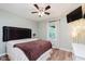 Comfortable bedroom with hardwood floors, fan, natural light, and mounted TV at 12535 Old Pond Rd, Noblesville, IN 46060