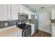 Kitchen showcasing stainless steel appliances, white cabinets, and stylish dark backsplash at 12848 Patrick Ct, Fishers, IN 46038