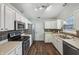 A bright kitchen features stainless steel appliances, white cabinets, and dark backsplash at 12848 Patrick Ct, Fishers, IN 46038