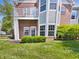 Brick condo building with a balcony, green lawn, and manicured landscaping at 1359 Shadow Ridge Rd, Indianapolis, IN 46280