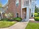 Brick condo building featuring manicured landscaping, green lawn, and sidewalk at 1359 Shadow Ridge Rd, Indianapolis, IN 46280