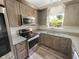 Well-lit kitchen with stainless steel appliances, granite countertops, and wood cabinets at 1359 Shadow Ridge Rd, Indianapolis, IN 46280