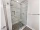 Modern shower with glass door, gray tiling, and built-in shelving at 1359 Shadow Ridge Rd, Indianapolis, IN 46280