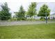 Green backyard with a retaining wall with lovely shrubbery behind the home at 16209 Natures Way, Westfield, IN 46074