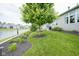 Well-manicured lawn backing up to a pond, with a cozy grill and patio area at 16209 Natures Way, Westfield, IN 46074