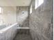 Modern bathroom featuring stone tile and a glass-enclosed shower with updated fixtures at 16209 Natures Way, Westfield, IN 46074