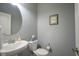 Charming half bathroom featuring a pedestal sink, round mirror and neutral decor at 16209 Natures Way, Westfield, IN 46074
