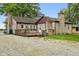 Home's exterior featuring a wooden deck, detached garage, and gravel landscape at 1631 S Post Rd, Indianapolis, IN 46239