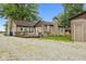 Spacious backyard with a wooden deck, stone accents, and detached garage at 1631 S Post Rd, Indianapolis, IN 46239