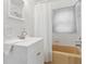 Bathroom with white vanity, tile walls, a shower with a white curtain, and a vintage-style tan bathtub at 1631 S Post Rd, Indianapolis, IN 46239