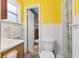 Bathroom with yellow walls, white tile, and a traditional-style vanity with ample counter space at 1631 S Post Rd, Indianapolis, IN 46239