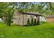 Home featuring stone exterior, green lawn, and decorative evergreen shrubbery at 1631 S Post Rd, Indianapolis, IN 46239