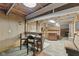 Basement living area with custom tables, chairs, and wood-paneled walls and ceilings at 1631 S Post Rd, Indianapolis, IN 46239