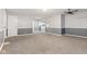 Open-concept living room with carpet, gray wainscoting, and view of kitchen at 1631 S Post Rd, Indianapolis, IN 46239