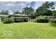 View of a spacious green backyard featuring mature trees and foliage, perfect for outdoor activities at 1802 Laurel Dr, Columbus, IN 47203