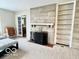 Neutral colored living room shows a stone fireplace with hearth and built in shelving at 1802 Laurel Dr, Columbus, IN 47203