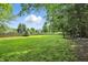 Picturesque backyard featuring lush green grass, mature trees, and fencing at 18112 Kinder Oak Dr, Noblesville, IN 46062