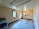 View of a large empty garage with a window, door, and overhead lighting, with peeling paint and lots of natural light at 1908 S Biltmore Ave, Muncie, IN 47302