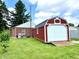 This property includes a detached two car garage, a brick house, and a green yard, all in a small town setting at 1908 S Biltmore Ave, Muncie, IN 47302