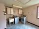 Picture of an empty laundry room with old washing machines, overhead cabinets, and a utility sink at 1908 S Biltmore Ave, Muncie, IN 47302