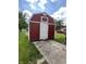 This property includes a shed with a white door, situated on a concrete slab, adjacent to a green lawn at 1908 S Biltmore Ave, Muncie, IN 47302
