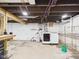 Unfinished basement with exposed ceiling, utility connections, and concrete flooring at 1910 W 10Th St, Anderson, IN 46016