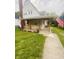 Inviting home showcasing a covered front porch, flagpole, and beautifully landscaped yard at 1910 W 10Th St, Anderson, IN 46016