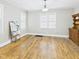 Open living room with hardwood floors, a large window, and a wooden accent cabinet at 1910 W 10Th St, Anderson, IN 46016