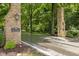 Elegant stone entrance to a private estate, surrounded by lush greenery and mature trees at 1927 E Derby Ct, Martinsville, IN 46151