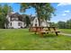 Exterior view of a large home with picnic tables in the front yard and mature trees at 1927 E Derby Ct, Martinsville, IN 46151