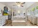Cozy main bedroom with a four-poster bed, ceiling fan, hardwood floors, and natural light at 1927 E Derby Ct, Martinsville, IN 46151