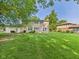 Traditional home's backyard featuring mature trees, green lawn and the exterior back of the home at 2126 Tartan Rd, Anderson, IN 46012