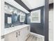 Bathroom with navy walls, double sink vanity, modern lighting, and tiled floors at 2126 Tartan Rd, Anderson, IN 46012