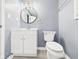 Light and airy bathroom featuring modern vanity, round mirror, and wood-look floors at 2126 Tartan Rd, Anderson, IN 46012