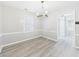 Empty dining room showcasing modern chandelier, chair rail, and hardwood floors at 2126 Tartan Rd, Anderson, IN 46012