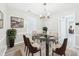Bright dining room featuring modern chandelier, glass table, neutral decor, and hardwood floors at 2126 Tartan Rd, Anderson, IN 46012