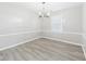Open dining area features modern chandelier, chair rail, and hardwood floors at 2126 Tartan Rd, Anderson, IN 46012