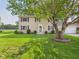 Traditional home with green shutters and a well-manicured front lawn and mature shade tree at 2126 Tartan Rd, Anderson, IN 46012