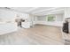 Open-concept living room and kitchen layout with light wood floors and a fireplace at 2126 Tartan Rd, Anderson, IN 46012