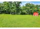 Spacious backyard with mature trees and a red storage barn at 2608 E 500 N, Whiteland, IN 46184