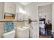 Bathroom featuring a mosaic tiled wall, sink with cabinet, toilet, and open doorway to a bedroom at 2608 E 500 N, Whiteland, IN 46184